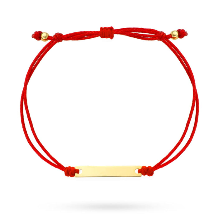 O brățară de aur cu o placă gravată pe un șnur roșu