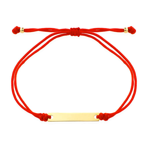 O brățară de aur cu o placă gravată pe un șnur roșu