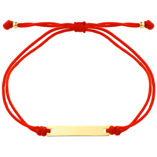 O brățară de aur cu o placă gravată pe un șnur roșu