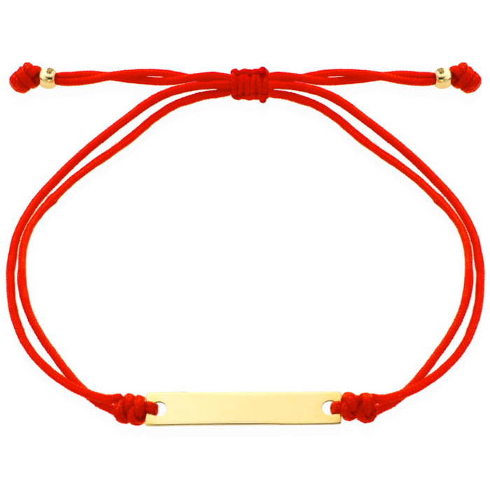 O brățară de aur cu o placă gravată pe un șnur roșu