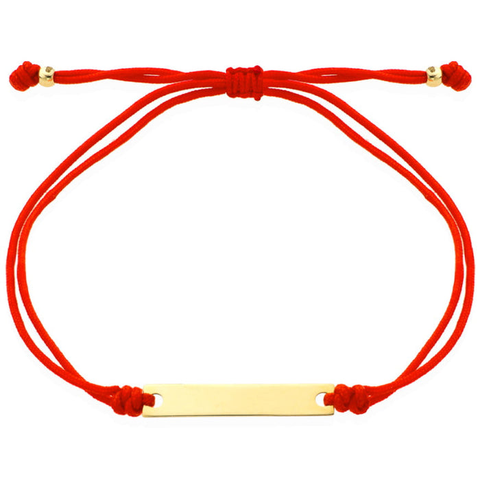 O brățară de aur cu o placă gravată pe un șnur roșu